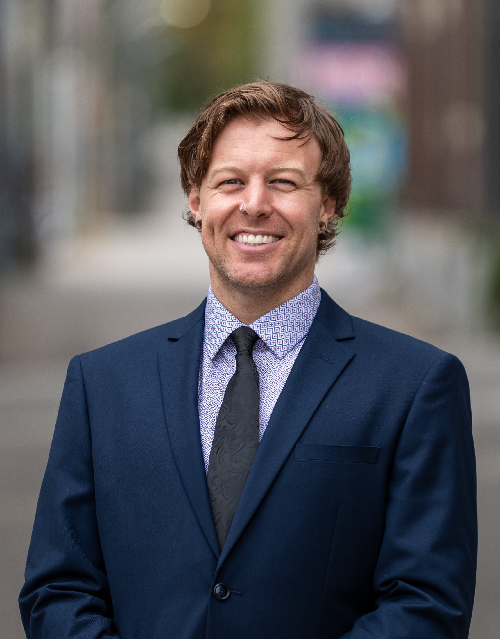 Tyson Alcock smiling in a blue shirt, representing nelson real estate with a personable approach.
